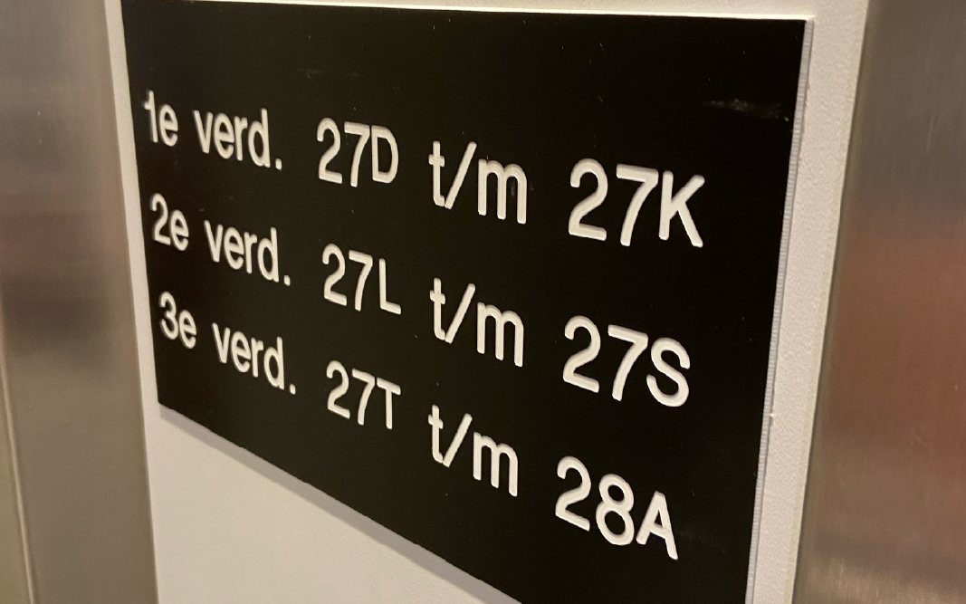 Zwart bord met witte letters dat de verdiepingen en vakken aangeeft